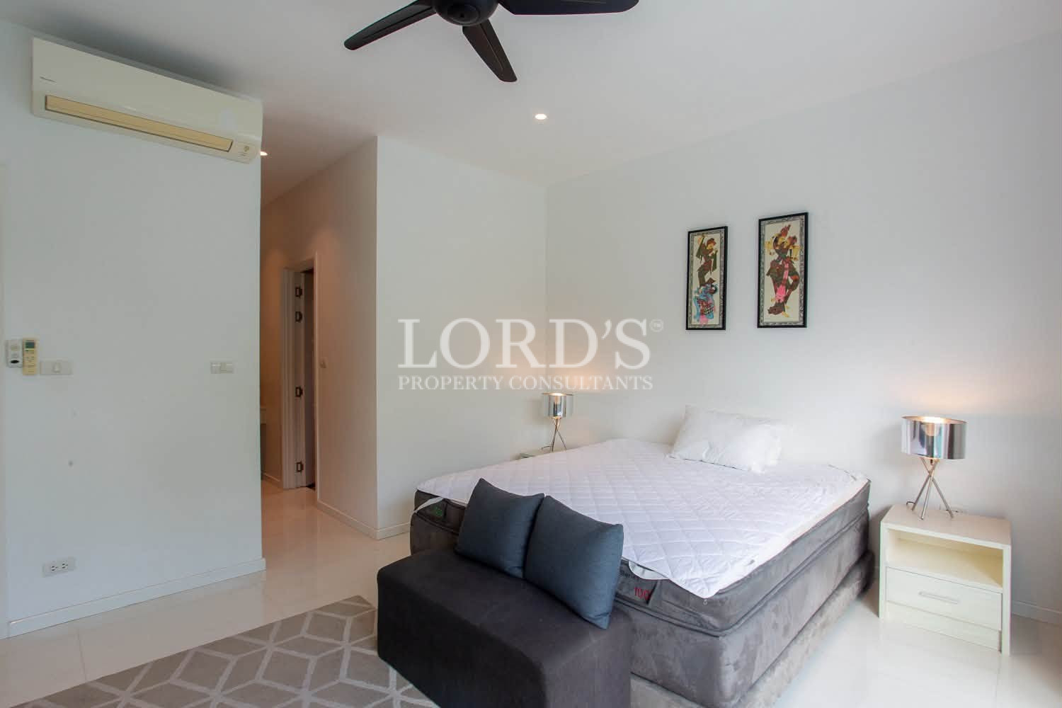 Bright bedroom with double bed, white bedding, and wall artwork