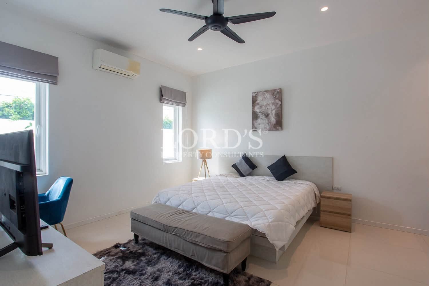 Comfortable bedroom with double bed, white bedding, pillows, and ceiling fan