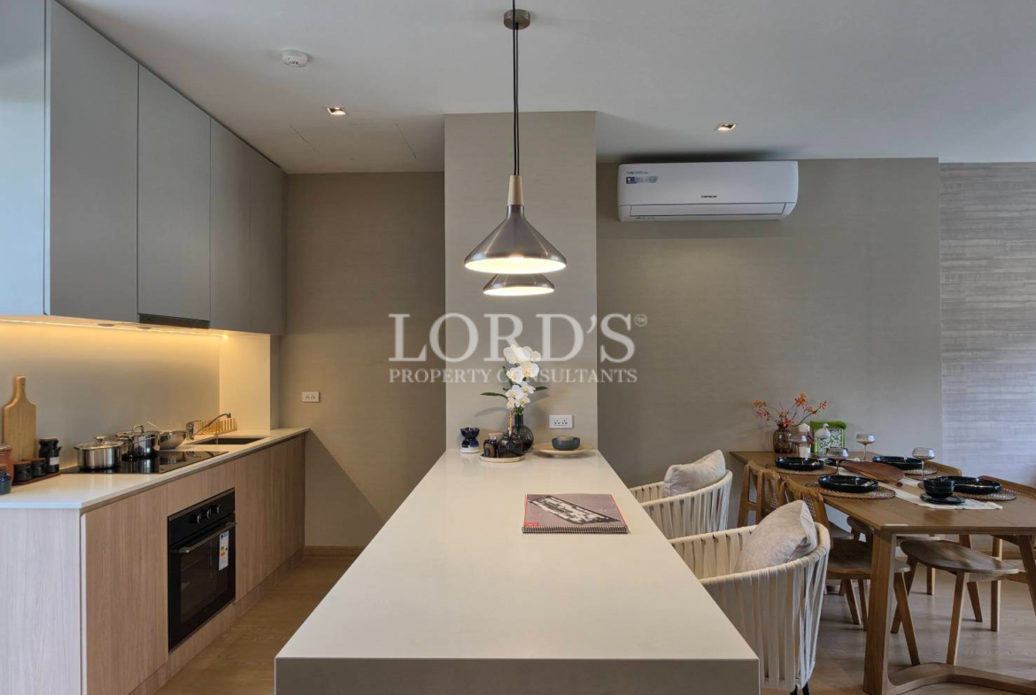 Modern kitchen and dining area with pendant lights, wooden cabinets, island counter, and air conditioner