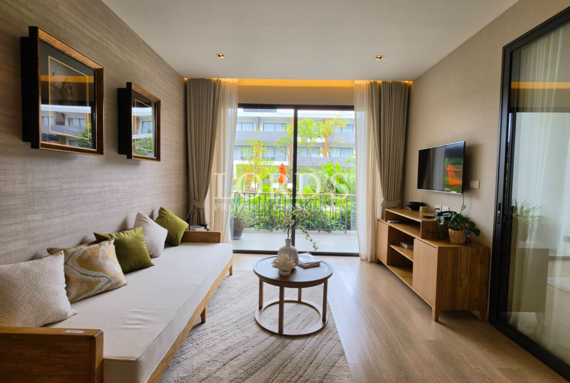 Bright modern living room with white sofa, large windows, curtains, TV, and garden view