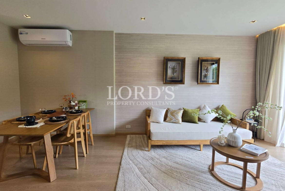 Modern living room with sectional sofa, coffee table, wall artwork, and large windows